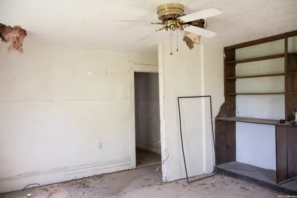 an empty room with windows and fan