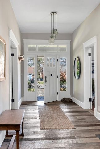 a view of a hallway with wooden floor and a chandelier