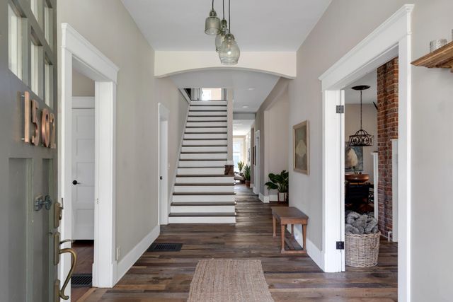 a view of a hallway with wooden floor and staircase