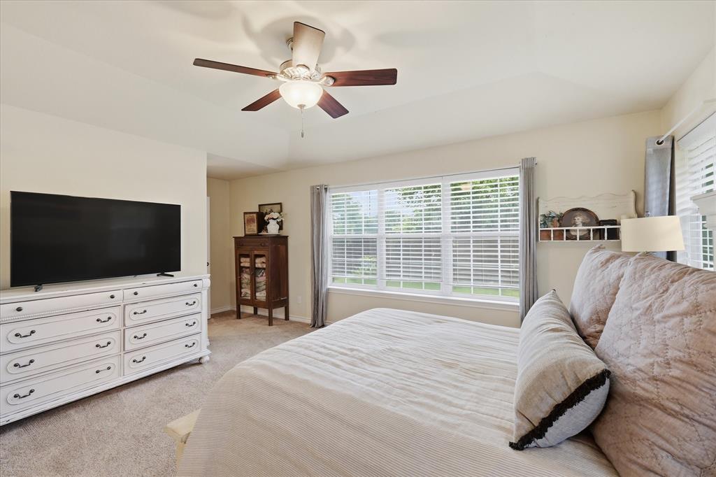 202 Colonial Heights Sanger, TX 76266 - Photo 15 of 27 a spacious bedroom with a bed a flat screen tv and a couch