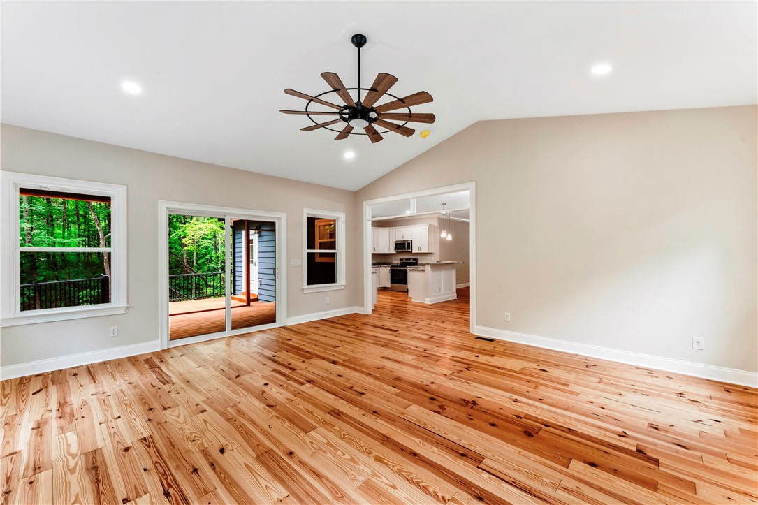 110 Gabriel Way Pickens, SC 29671 - Photo 14 of 48 Bright hardwood flooring anchors this open-concept living space, offering outdoor deck access and seamless flow into the kitchen.