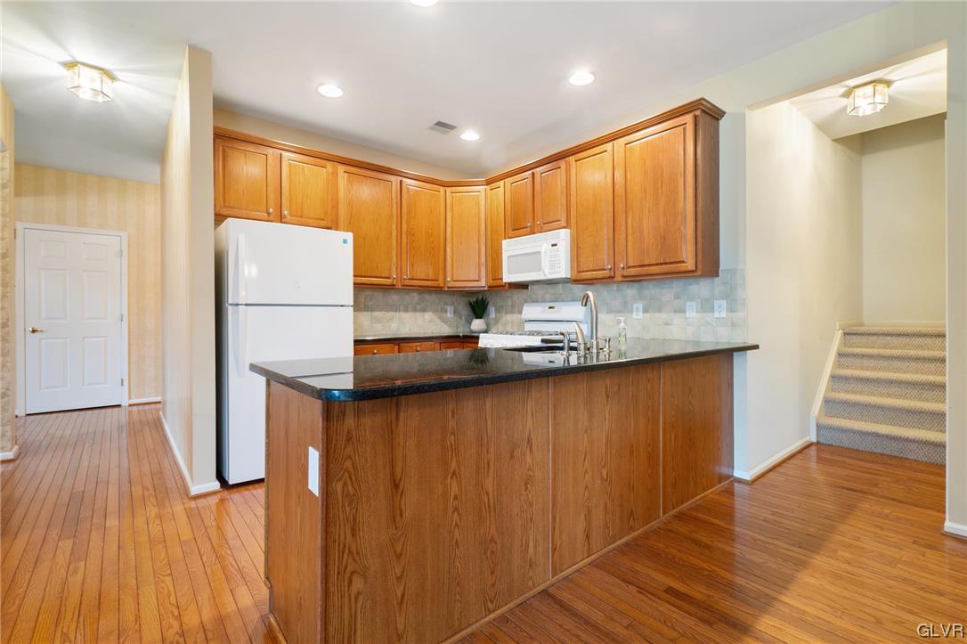 1882 Gregory Place Hellertown, PA 18055 - Photo 9 of 28 a kitchen with stainless steel appliances granite countertop a refrigerator a sink dishwasher and wooden cabinets with wooden floor