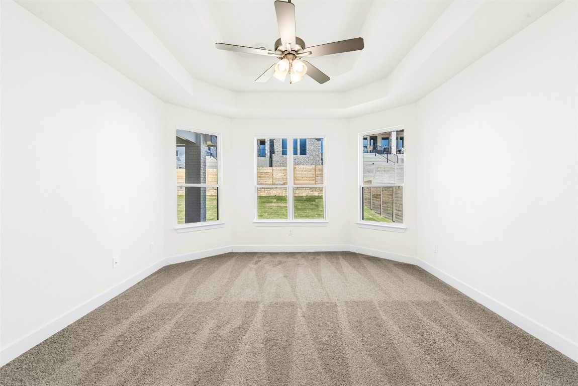 1520 Rodeo Ridge Drive Georgetown, TX 78628 - Photo 7 of 29 Carpeted empty room featuring a tray ceiling and a ceiling fan