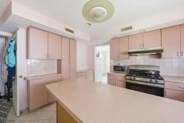 a kitchen with kitchen island granite countertop a stove a sink and a refrigerator