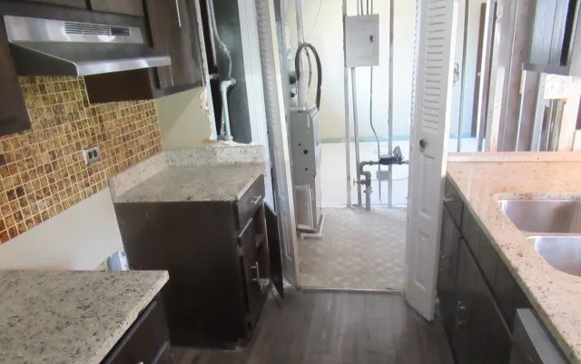 a en suite bathroom with a granite countertop sink and a mirror