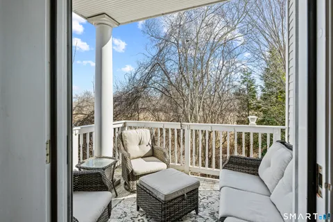 a balcony with wooden floor and outdoor seating