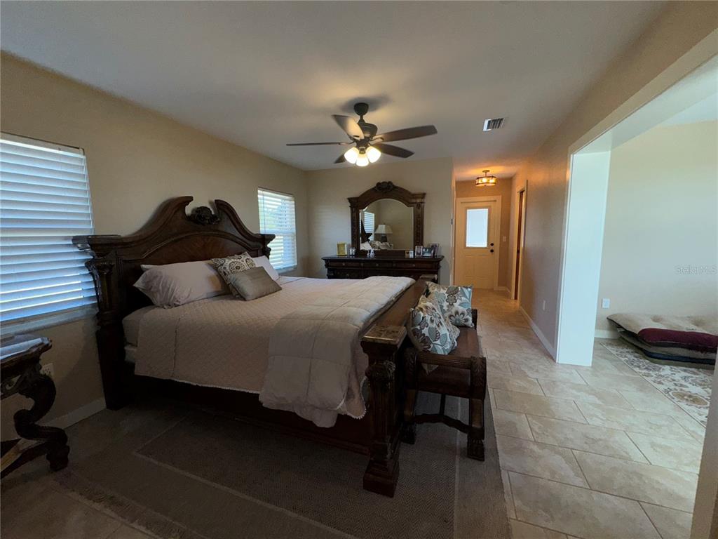 1893 North Lake Reedy Boulevard Frostproof, FL 33843 - Photo 17 of 56 a bedroom with a bed and a chandelier