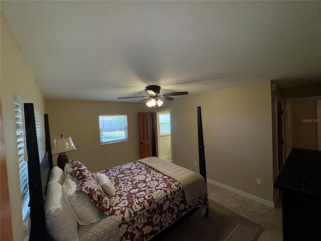 1893 North Lake Reedy Boulevard Frostproof, FL 33843 - Photo 23 of 56 a bedroom with a bed and a chandelier
