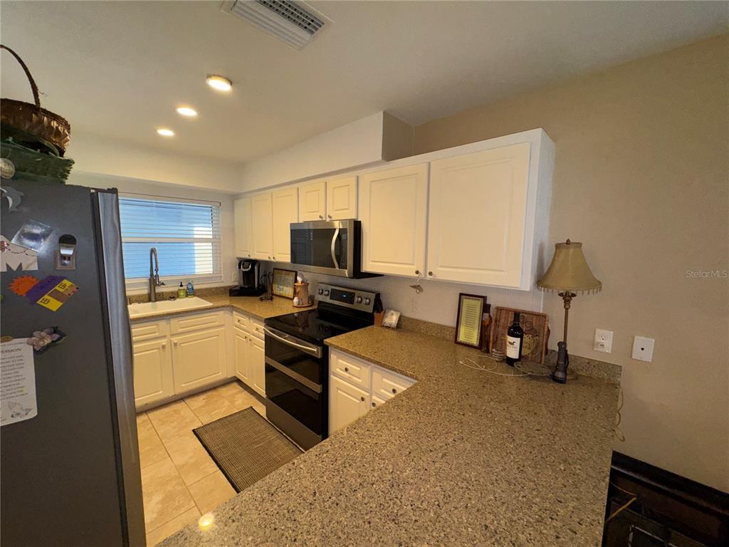 1893 North Lake Reedy Boulevard Frostproof, FL 33843 - Photo 7 of 56 a kitchen with a refrigerator and a stove top oven