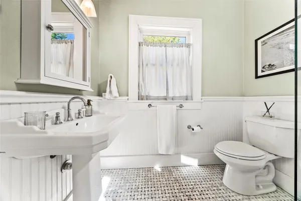 a bathroom with a sink toilet and window