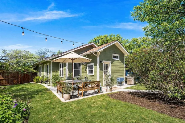 a view of a house with backyard and sitting area