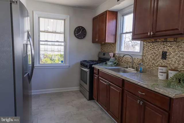 a kitchen with granite countertop wooden cabinets and stainless steel appliances
