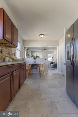 an empty room with chandelier fan and windows