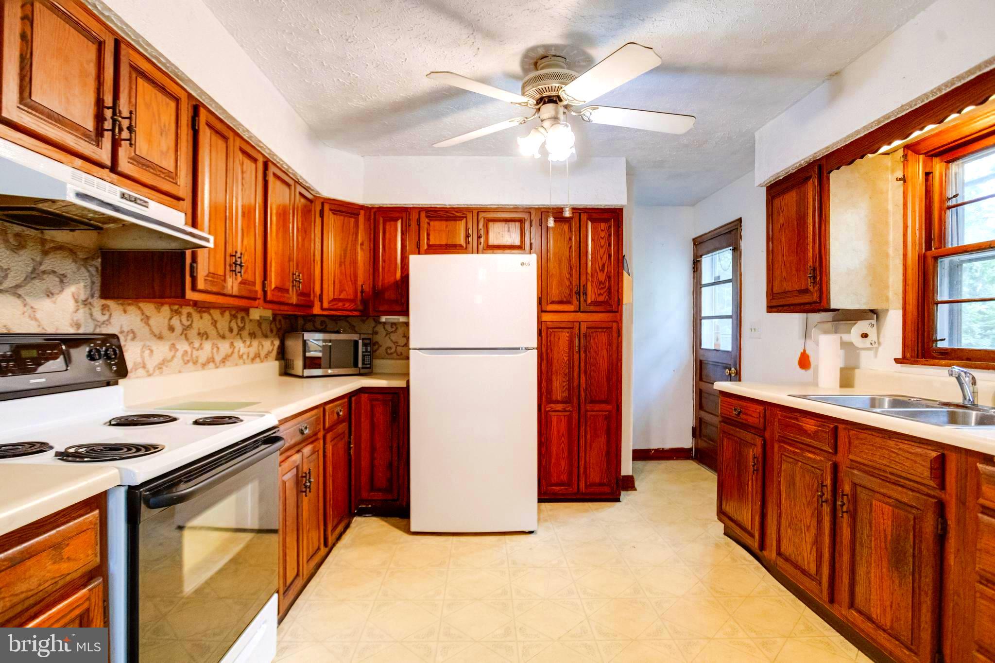 1405 Pomeroy Avenue Abingdon, MD 21009 - Photo 15 of 60 a kitchen with stainless steel appliances granite countertop a refrigerator a stove top oven a sink dishwasher and wooden cabinets