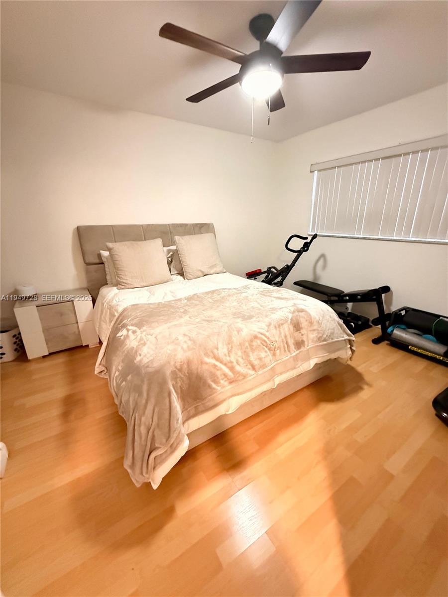 5790 Stirling Road, Unit 104 Hollywood, FL 33021 - Photo 14 of 19 a bedroom with a bed and ceiling fan