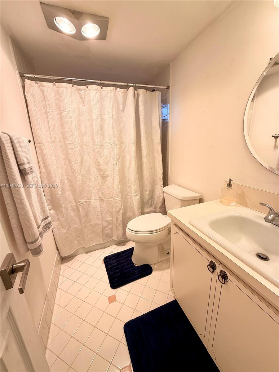 5790 Stirling Road, Unit 104 Hollywood, FL 33021 - Photo 18 of 19 a bathroom with a sink a toilet and a mirror