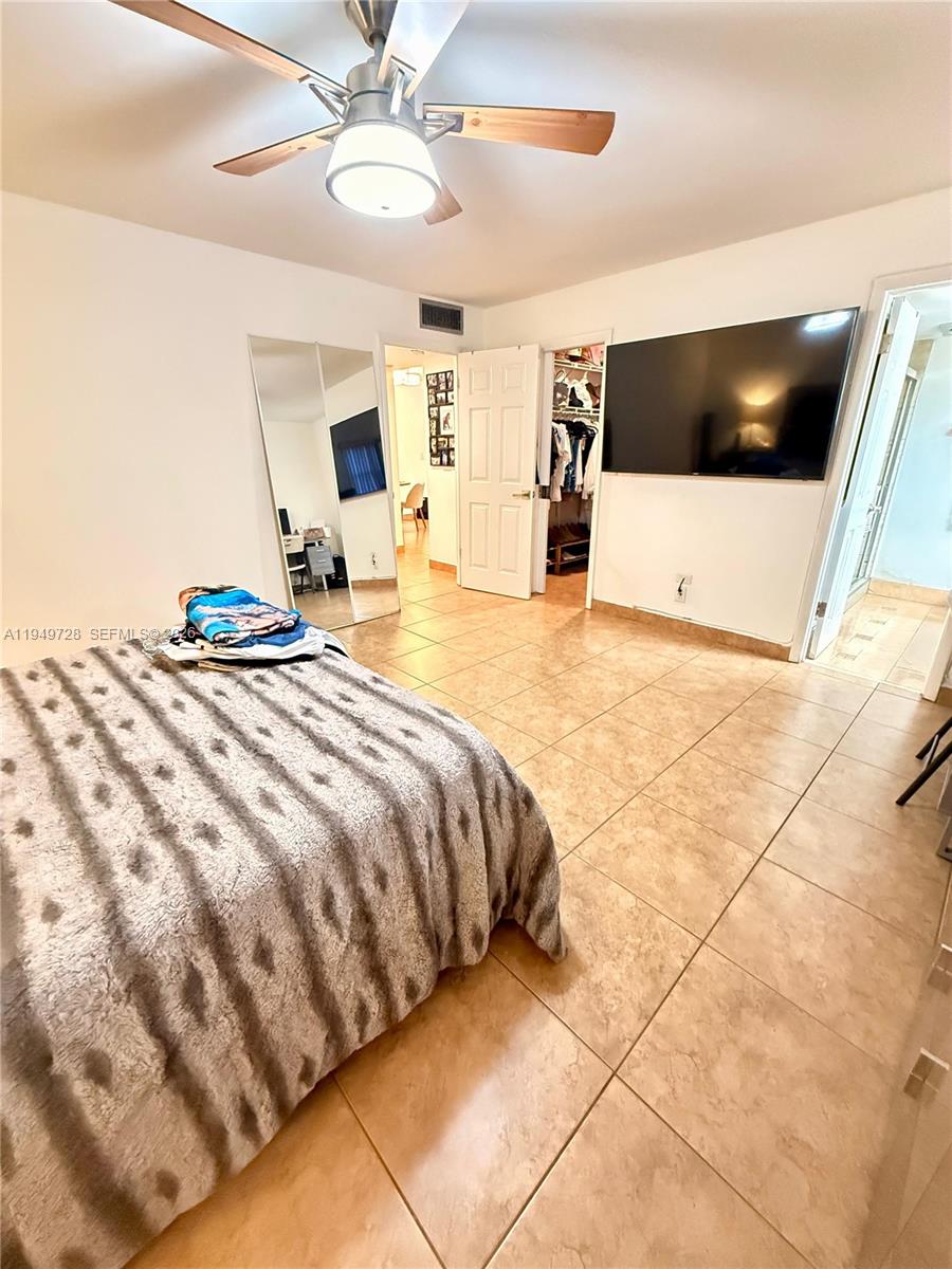 5790 Stirling Road, Unit 104 Hollywood, FL 33021 - Photo 7 of 19 a bedroom with a bed and a flat screen tv