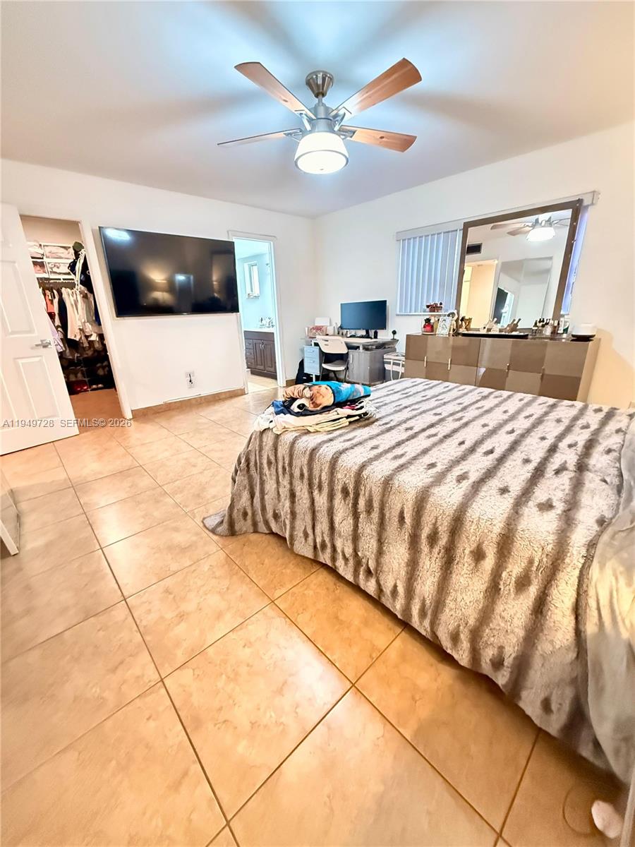 5790 Stirling Road, Unit 104 Hollywood, FL 33021 - Photo 8 of 19 a bedroom with a large bed and a flat screen tv