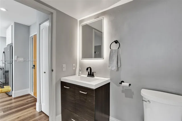 a bathroom with a sink a toilet and a mirror