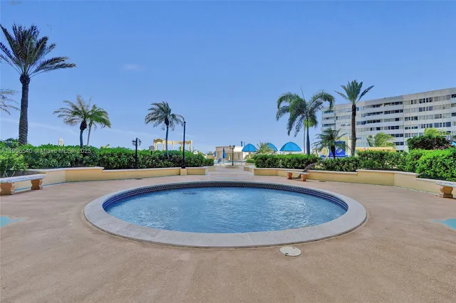 a swimming pool with outdoor seating and plants