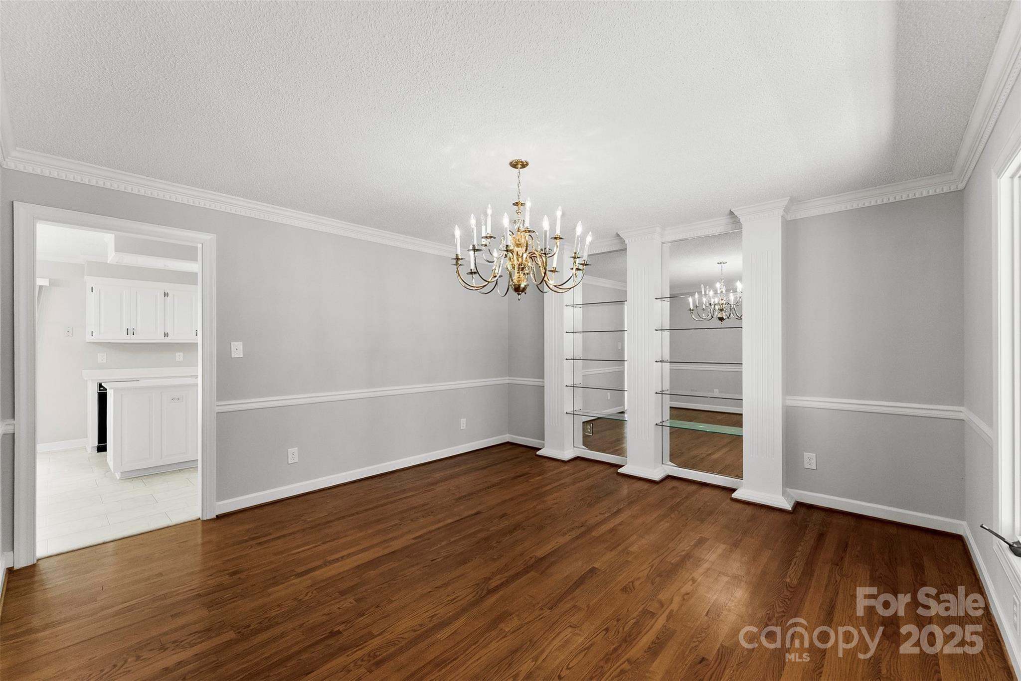 1505 North Cansler Street Kings Mountain, NC 28086 - Photo 12 of 46 an empty room with wooden floor chandelier and windows