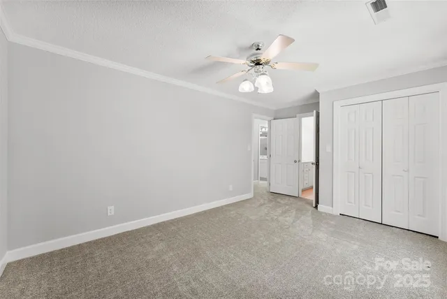 a view of an empty room and chandelier fan