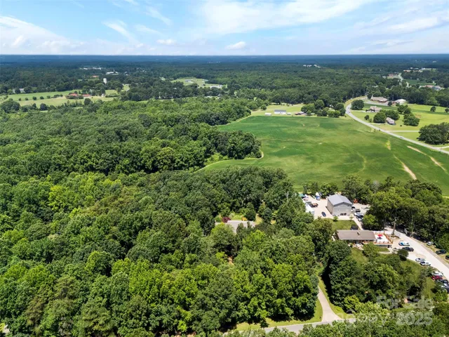 an aerial view of residential houses with outdoor space and trees