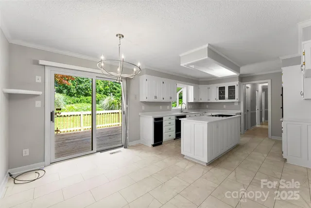 a large white kitchen with granite countertop a stove a sink dishwasher and a refrigerator