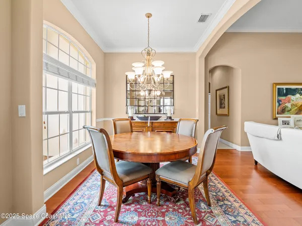 a large kitchen with stainless steel appliances kitchen island granite countertop a refrigerator oven a sink dishwasher and white cabinets with wooden floor