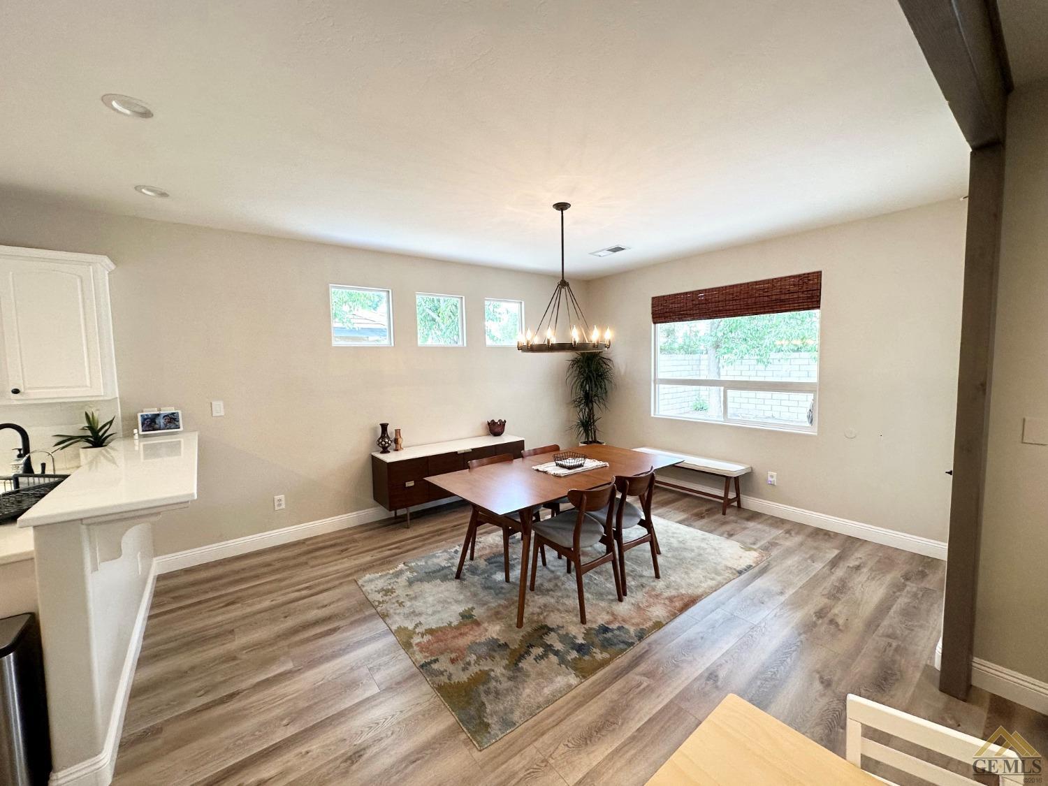 Undisclosed Address Bakersfield, CA 93311 - Photo 6 of 30 a dining room with wooden floor a chandelier a wooden table and chairs