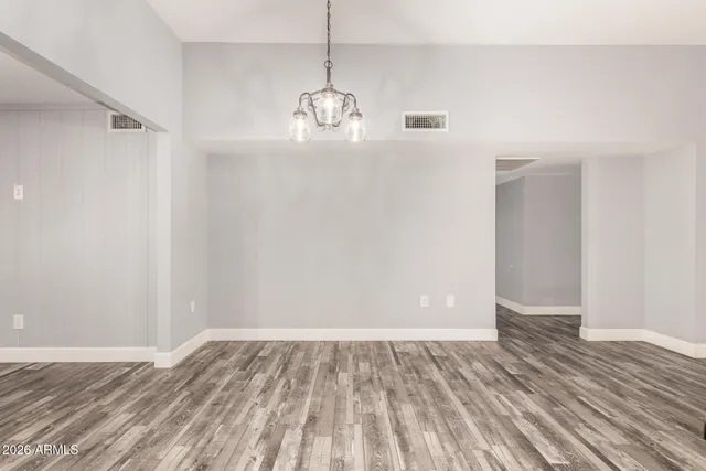 a view of an empty room and chandelier fan