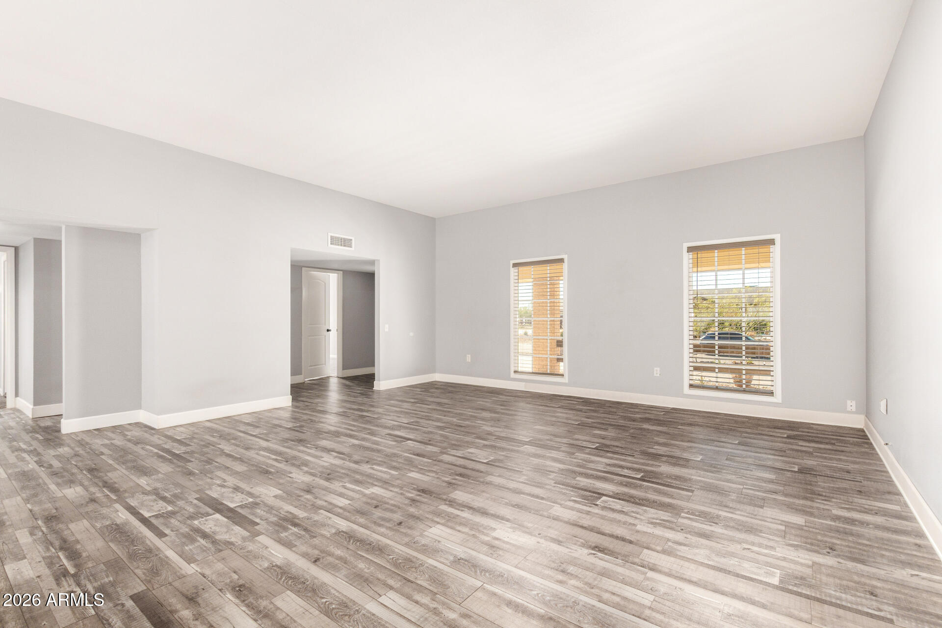 11118 West Mountain View Road Sun City, AZ 85351 - Photo 8 of 34 a view of an empty room with wooden floor and a window