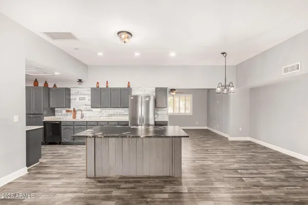 a large kitchen with stainless steel appliances kitchen island granite countertop a large stove a sink and a refrigerator