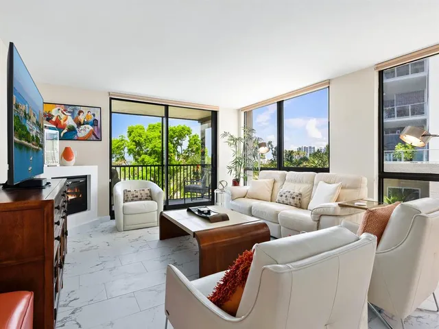 a living room with furniture a large window and a flat screen tv