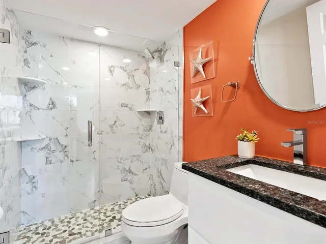 a bathroom with a granite countertop sink a shower and a mirror