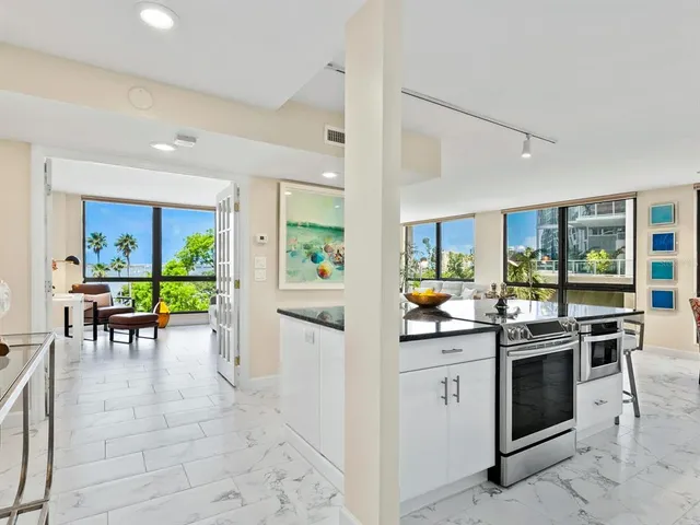 a kitchen with stainless steel appliances granite countertop a sink a stove and a refrigerator