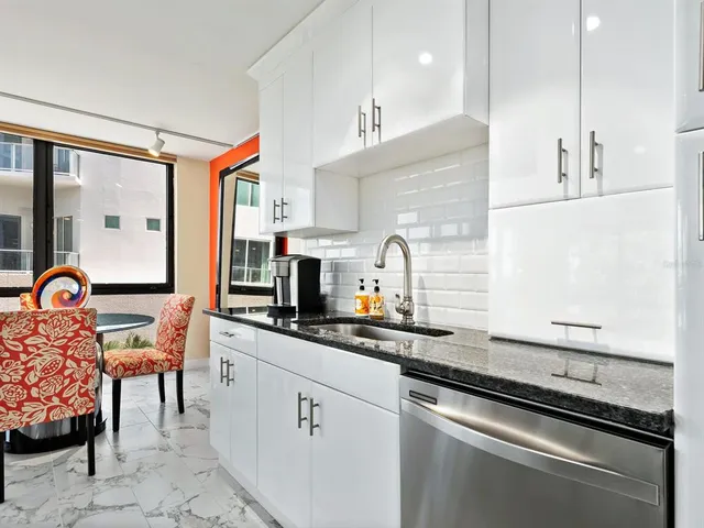 a kitchen with stainless steel appliances granite countertop a stove a sink and a refrigerator