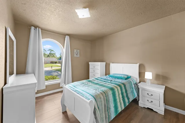 a bedroom with a large bed and a chandelier