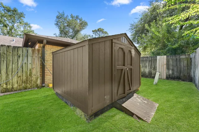 a view of a backyard with plants and large trees