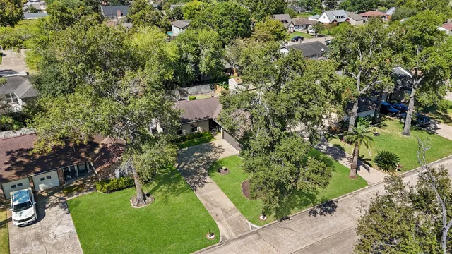 an aerial view of a house with swimming pool and garden
