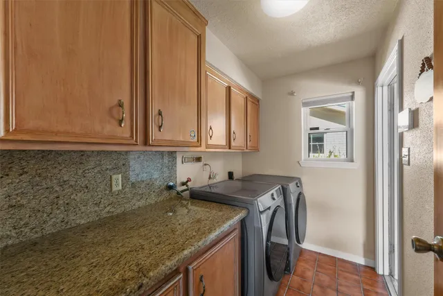 a utility room with granite countertop a sink a washer and dryer