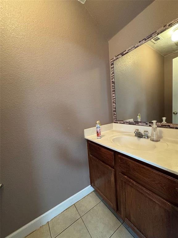 3200 Crownover Street Austin, TX 78725 - Photo 23 of 23 A well-appointed bathroom vanity with ample storage below a tiled mirror.