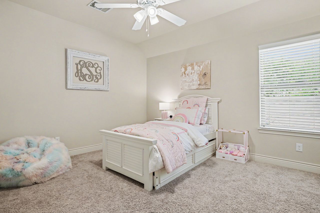 809 Prairie Dunes Drive Georgetown, TX 78628 - Photo 31 of 40 A well-lit bedroom features plush carpeting and a white ceiling fan, offering a comfortable personal retreat.