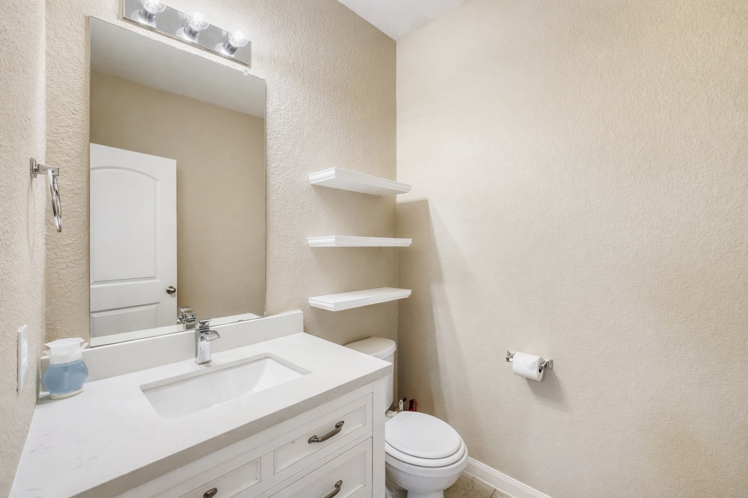 19621 Woodrow Wilson Street Manor, TX 78653 - Photo 12 of 34 a bathroom with a sink a toilet a mirror and vanity