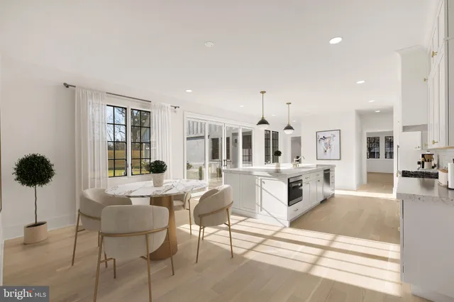 a living room with furniture a rug kitchen view and a large window