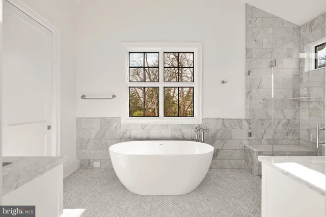 a white bath tub sitting in a bathroom next to a window