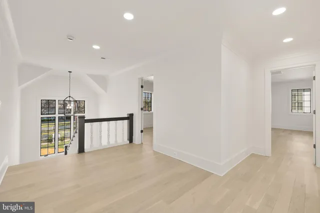 a view of empty room with wooden floor and windows