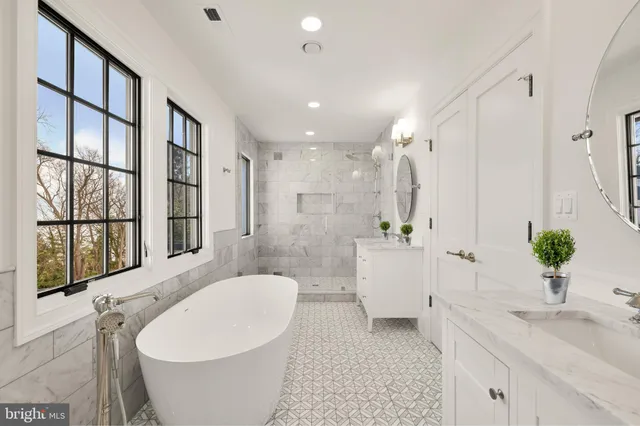 a bathroom with a white tub a sink a window and a shower