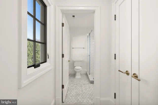 a bathroom with a toilet shower and a window