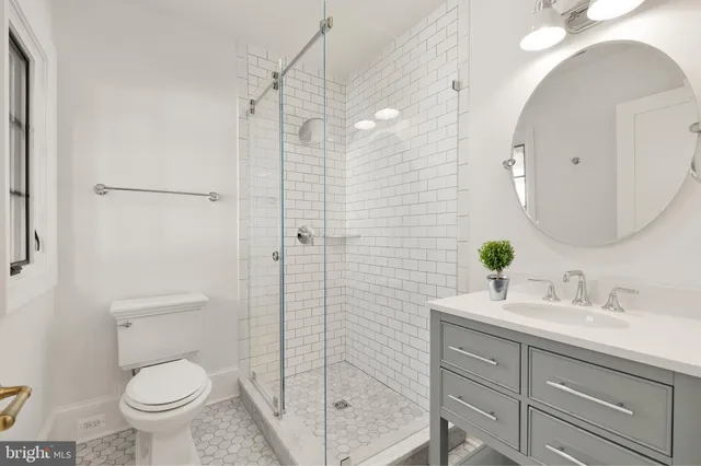 a bathroom with a granite countertop sink a toilet and shower